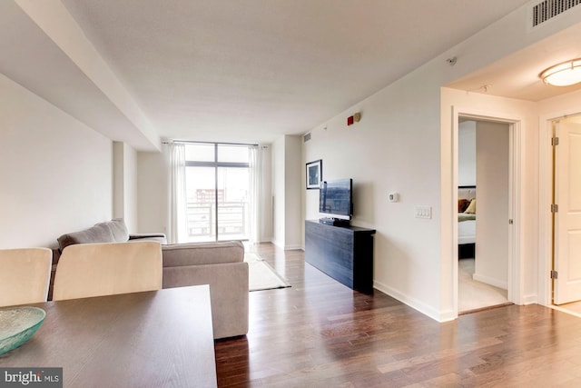 unfurnished living room featuring visible vents, baseboards, and wood finished floors