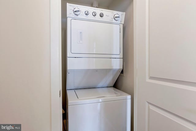 clothes washing area with laundry area and stacked washing maching and dryer