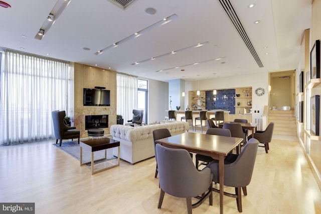 dining space featuring visible vents, a fireplace, and light wood-style floors