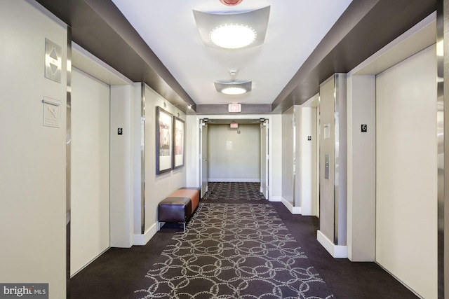 hall with elevator and baseboards