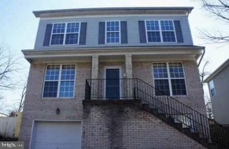 view of front facade featuring a porch, stairs, and a garage