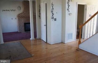 interior space with a fireplace, stairway, wood finished floors, and a wealth of natural light