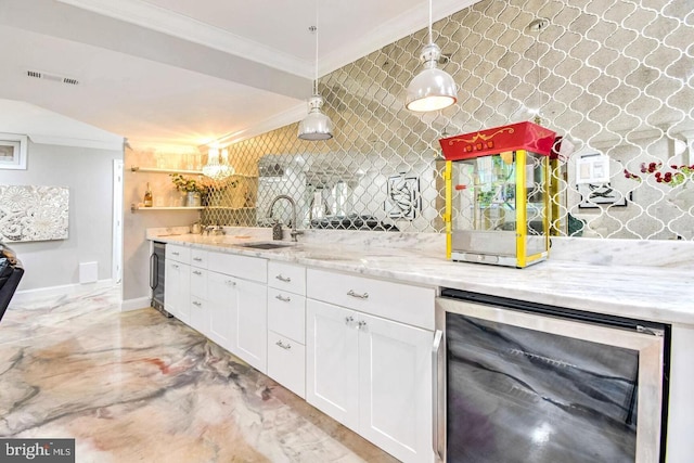 kitchen featuring visible vents, a sink, wine cooler, white cabinetry, and crown molding