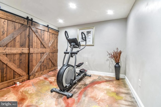 workout area with a barn door and baseboards