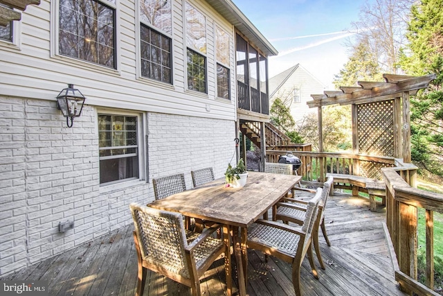 wooden deck with outdoor dining space, stairs, and a sunroom