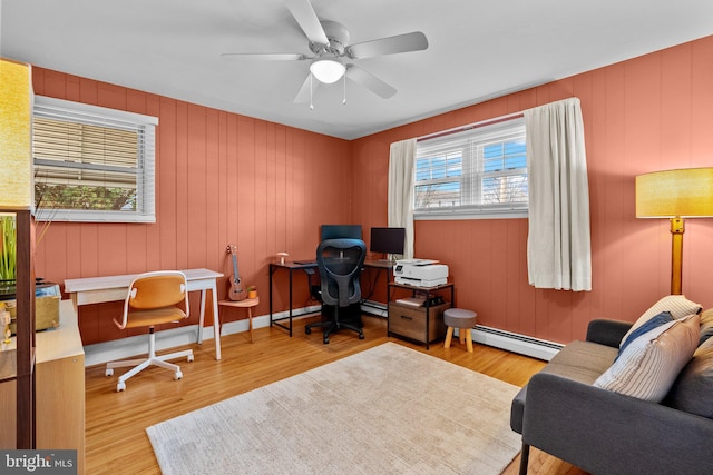 office space featuring baseboards, wood finished floors, a ceiling fan, and a baseboard radiator