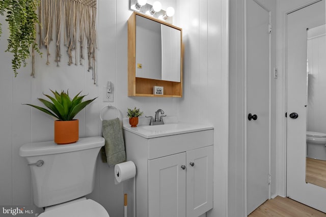 bathroom with vanity, toilet, and wood finished floors