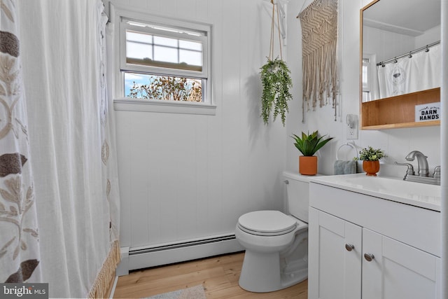 full bathroom featuring a baseboard heating unit, vanity, toilet, and wood finished floors