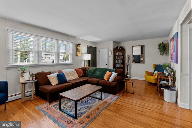 living room with light wood-style floors, baseboards, and a baseboard radiator