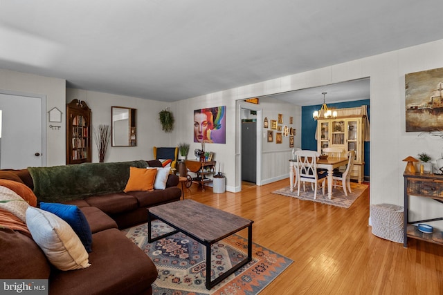 living room featuring light wood-style floors and an inviting chandelier