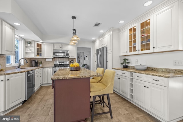 kitchen with visible vents, open shelves, a center island, stainless steel appliances, and a sink