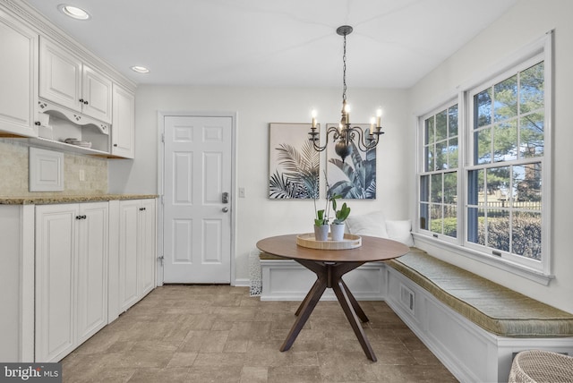 dining area with visible vents, stone finish floor, breakfast area, recessed lighting, and a chandelier