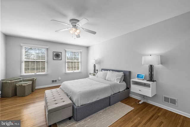 bedroom with visible vents, baseboards, and wood finished floors