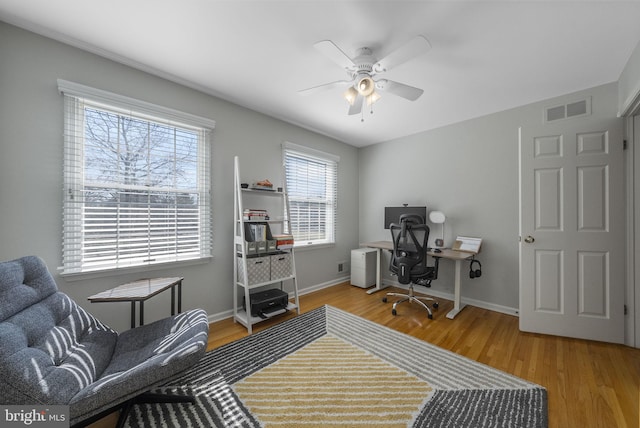 office space featuring visible vents, baseboards, and wood finished floors