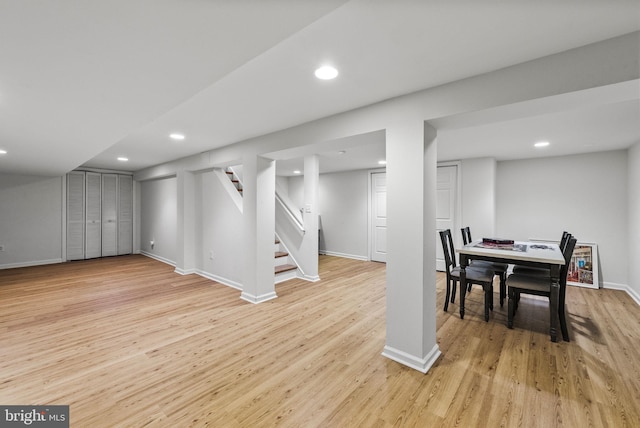 finished below grade area with stairway, recessed lighting, baseboards, and light wood-style floors