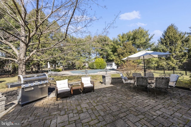 view of patio / terrace with a fenced in pool, a grill, and fence