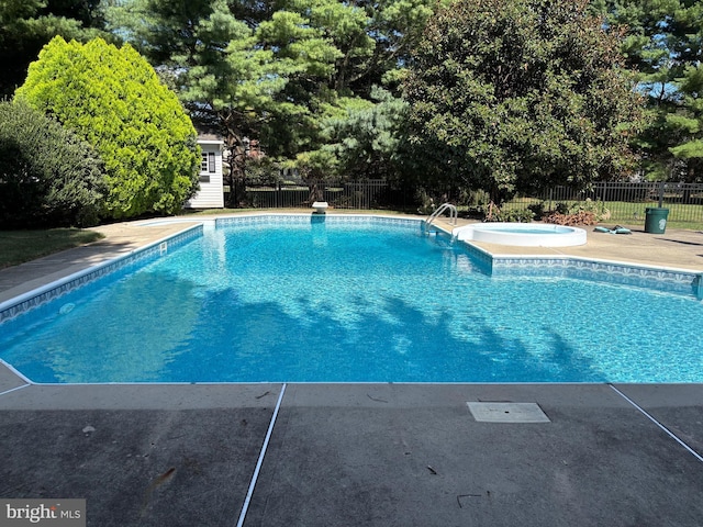 view of pool with a fenced in pool, an outbuilding, an in ground hot tub, and fence