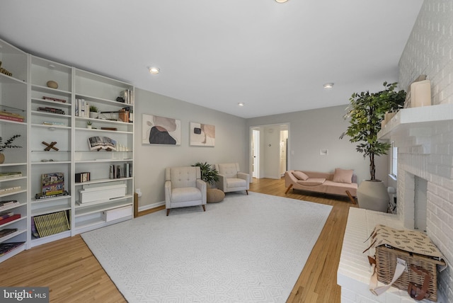 living room with light wood finished floors, recessed lighting, and a fireplace