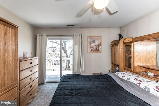 carpeted bedroom with access to exterior, visible vents, and a ceiling fan