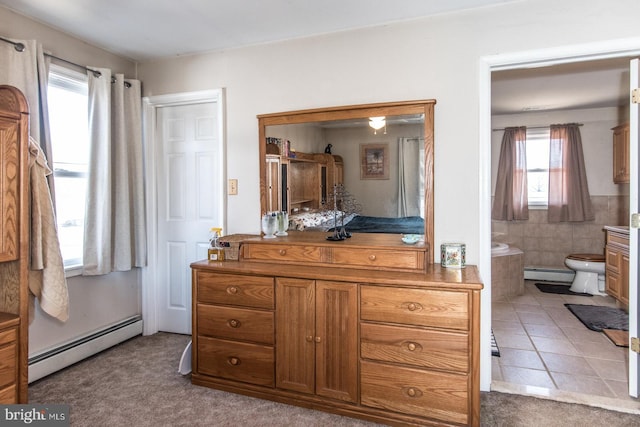 bathroom featuring a relaxing tiled tub, a baseboard radiator, vanity, and tile patterned flooring