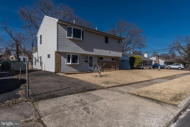 rear view of house featuring driveway and a gate