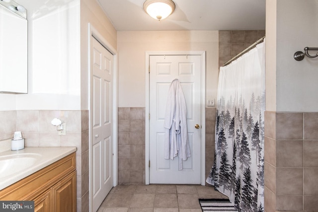 bathroom featuring tile patterned floors, curtained shower, tile walls, and vanity