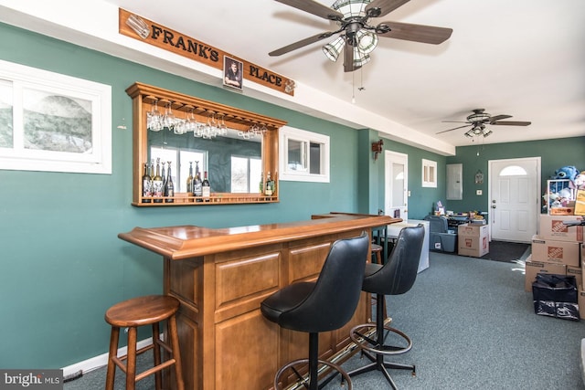 bar with a bar, electric panel, baseboards, and carpet floors