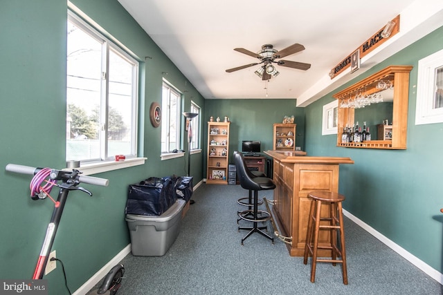 carpeted office featuring ceiling fan, a dry bar, and baseboards