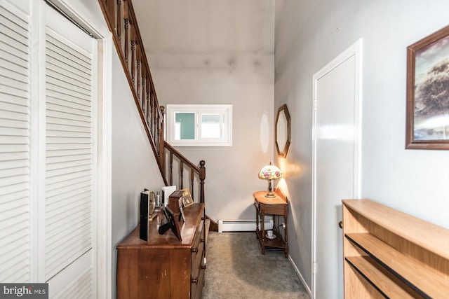 hallway featuring stairs, a baseboard heating unit, and dark carpet