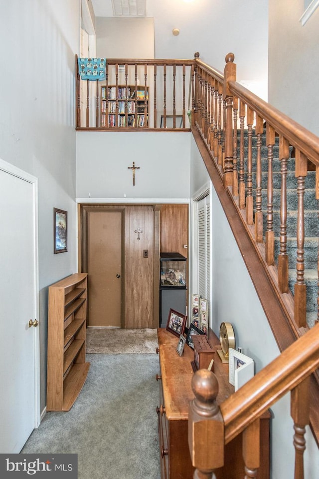 stairway with carpet flooring and a high ceiling