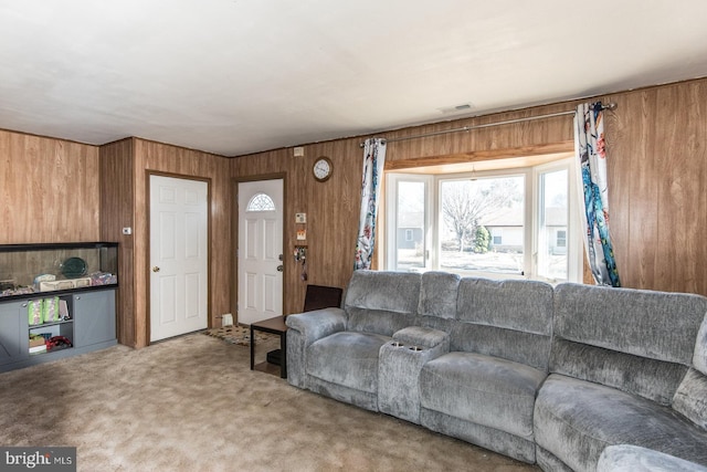 living area featuring visible vents, carpet, and wooden walls