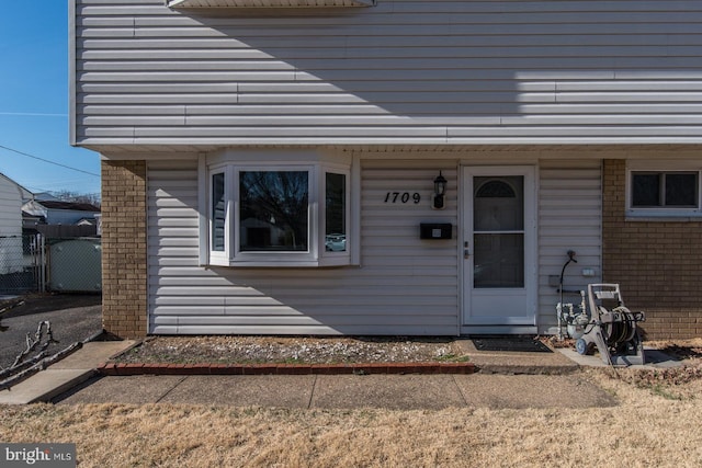 view of exterior entry with brick siding