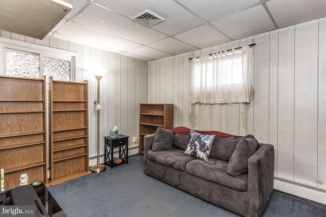 living area featuring a paneled ceiling, visible vents, baseboard heating, and carpet floors