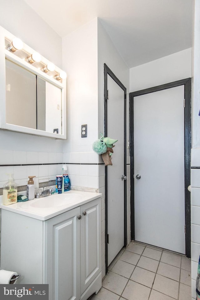 bathroom featuring tile patterned floors, vanity, and tile walls