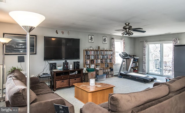 carpeted living area with ceiling fan