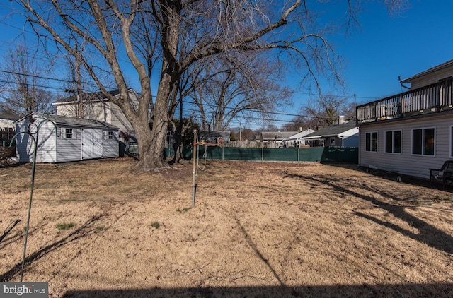 view of yard with an outdoor structure, fence, and a shed