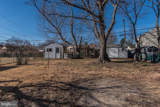 view of yard with an outdoor structure, fence, and a shed