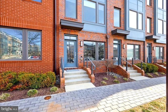 view of exterior entry featuring brick siding