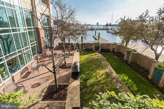 view of yard featuring a water view, a fenced backyard, and a patio area