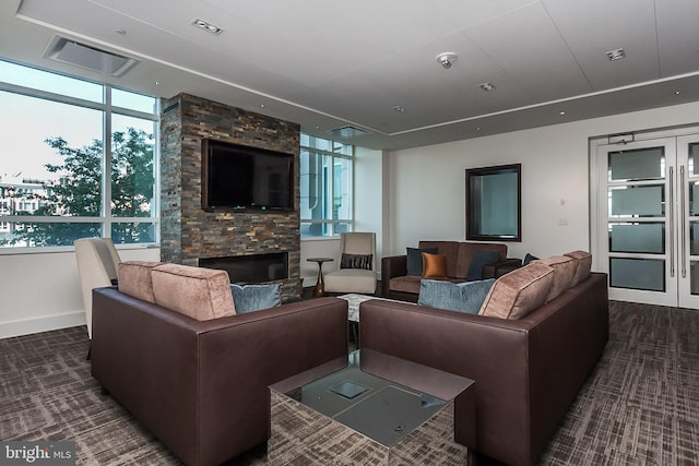 carpeted living room with plenty of natural light, a fireplace, baseboards, and visible vents