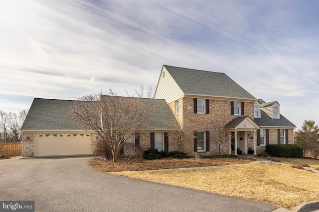 view of front of home with brick siding, driveway, a garage, and roof with shingles