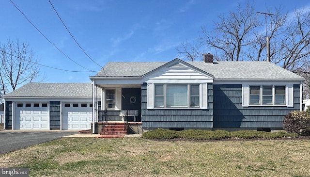 bungalow-style home featuring a front lawn, driveway, a shingled roof, and a garage