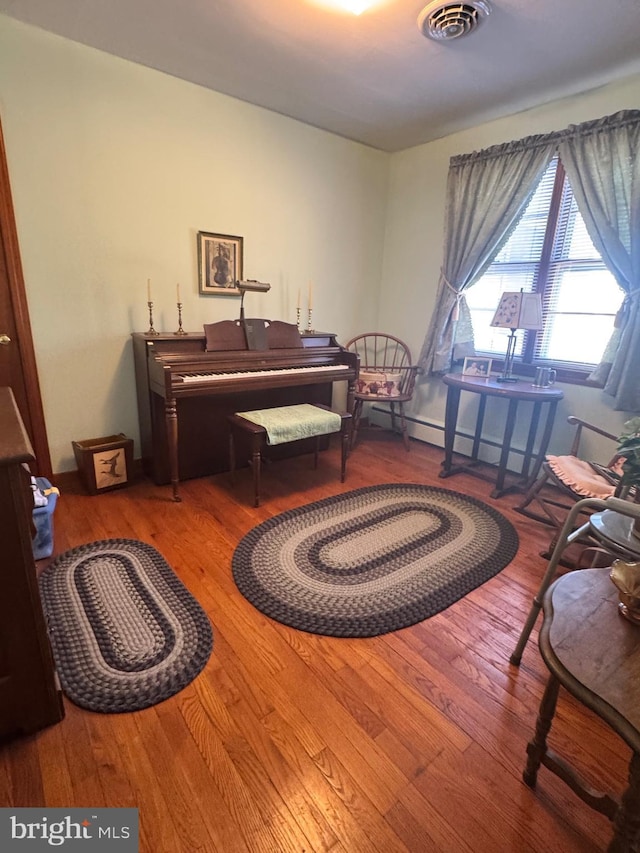 living area with visible vents and wood finished floors