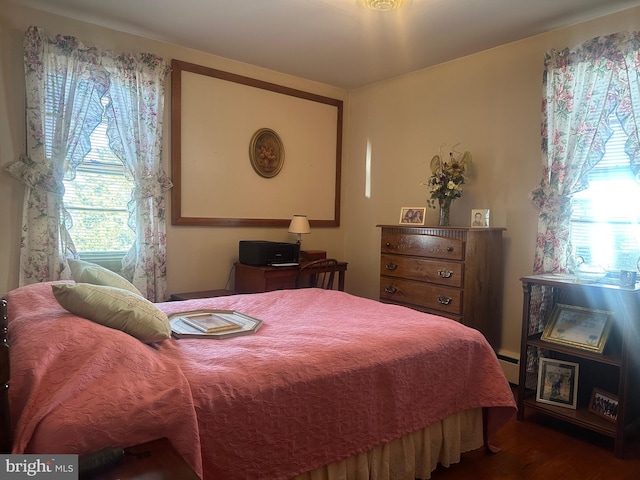 bedroom featuring wood finished floors and baseboard heating