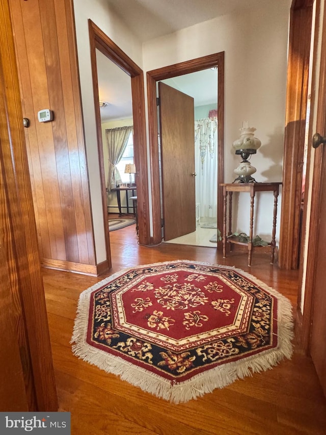 hall with baseboards and wood finished floors