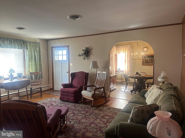 living area with arched walkways, visible vents, crown molding, and wood finished floors