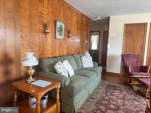 living area with wooden walls, attic access, and wood finished floors