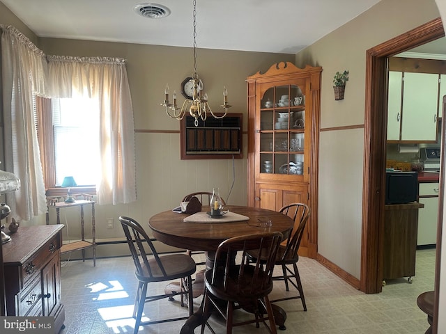 dining area featuring visible vents, light floors, an AC wall unit, and a notable chandelier