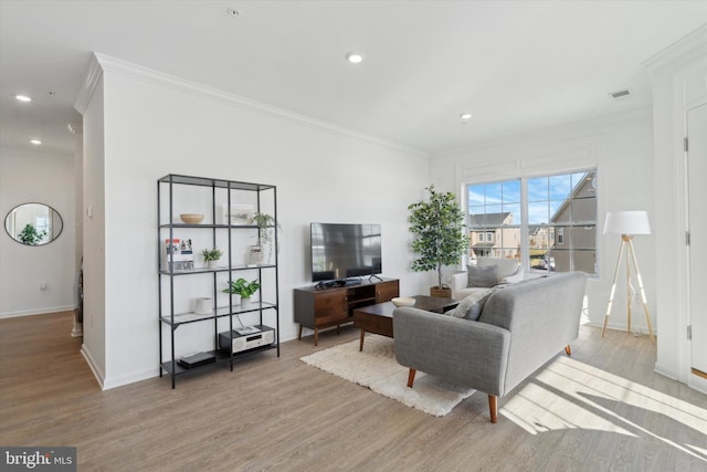 living area featuring visible vents, wood finished floors, and crown molding