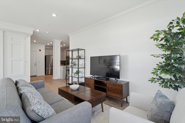 living room with decorative columns, recessed lighting, light wood-type flooring, and ornamental molding